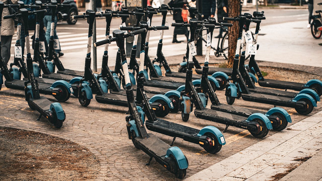 Multiple electric scooters parked on a cobblestone street in Florence, Italy, ready for use.